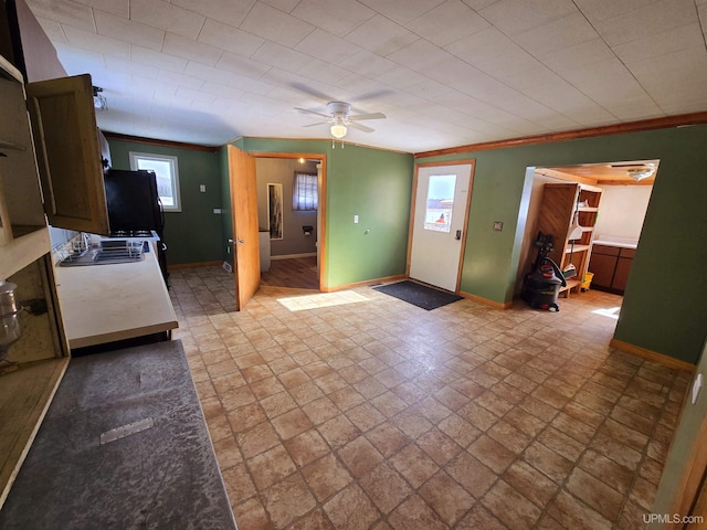 kitchen featuring ceiling fan, baseboards, freestanding refrigerator, and ornamental molding