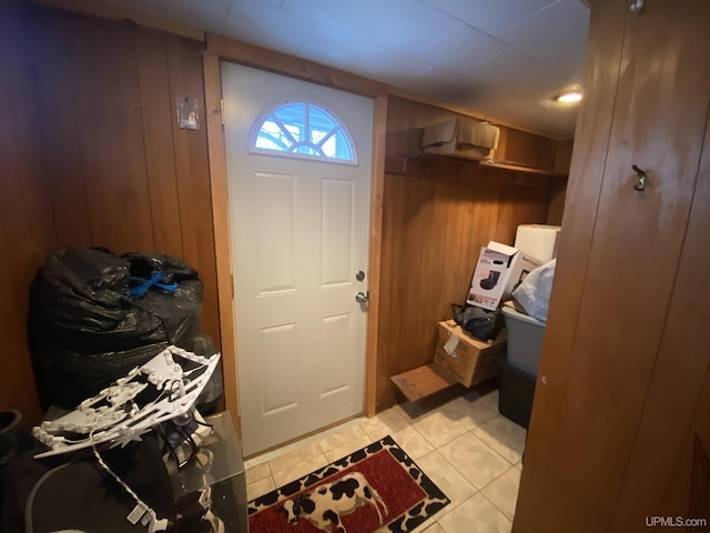 interior space featuring light tile patterned flooring and wooden walls