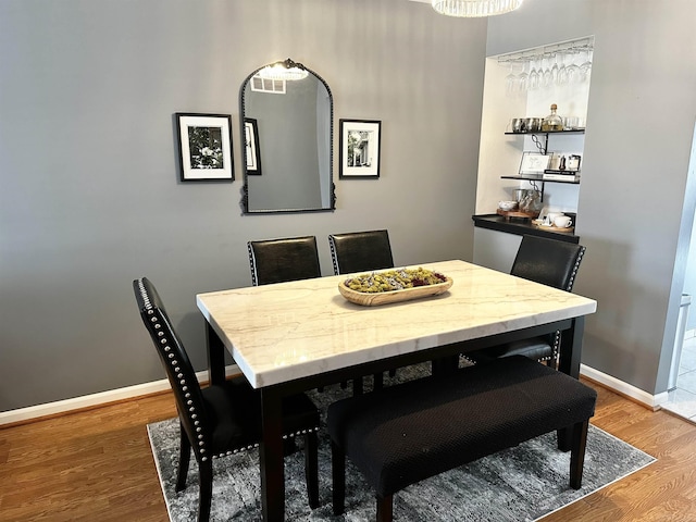 dining space featuring wood finished floors and baseboards