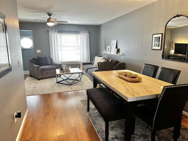 dining area featuring baseboards, wood finished floors, and a ceiling fan