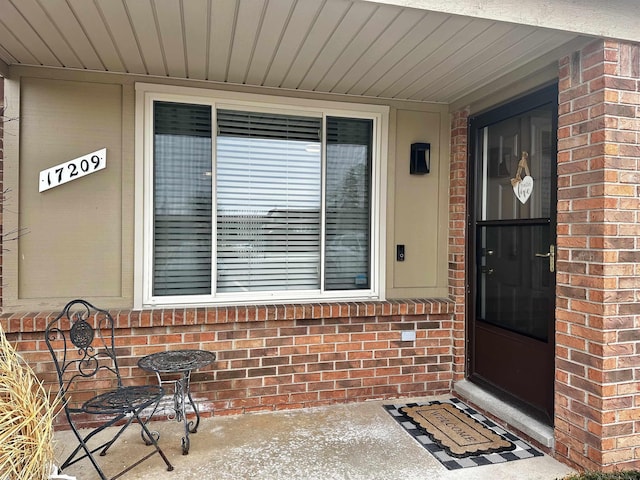 doorway to property featuring brick siding