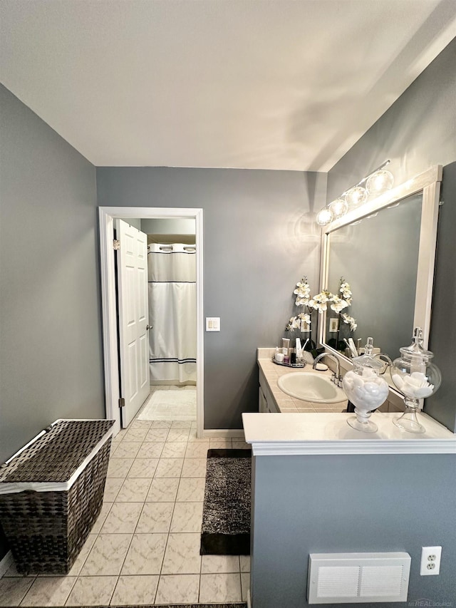 full bathroom featuring a shower with shower curtain, baseboards, marble finish floor, and vanity