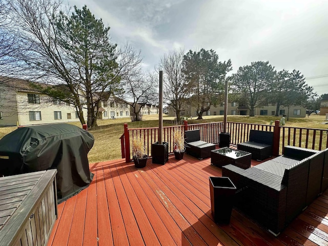 deck with area for grilling, a yard, and an outdoor living space with a fire pit