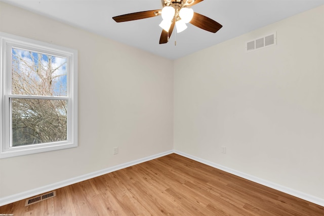 empty room with visible vents, baseboards, a ceiling fan, and light wood finished floors