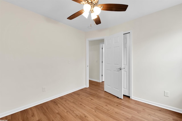 spare room with baseboards, light wood-style flooring, and a ceiling fan