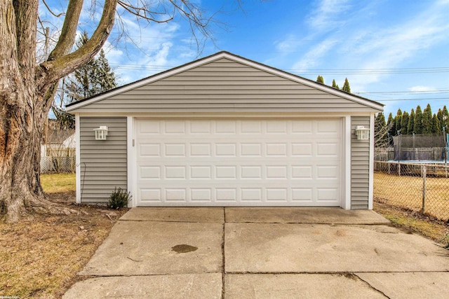 detached garage with a trampoline and fence