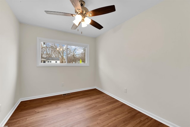 unfurnished room featuring visible vents, ceiling fan, baseboards, and wood finished floors