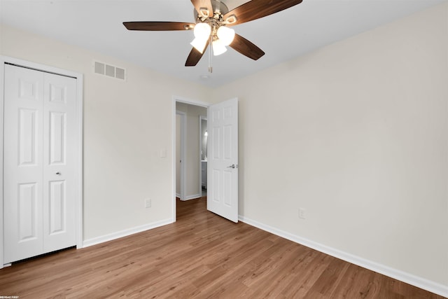 unfurnished bedroom with visible vents, baseboards, a closet, and light wood finished floors