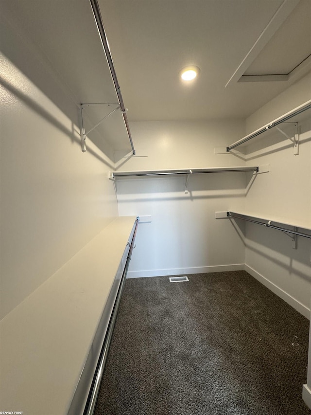 spacious closet with visible vents and dark carpet