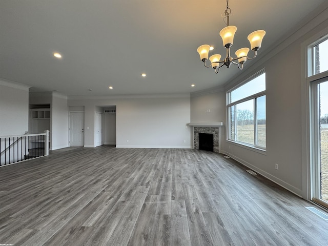 unfurnished living room featuring a fireplace, crown molding, baseboards, and wood finished floors