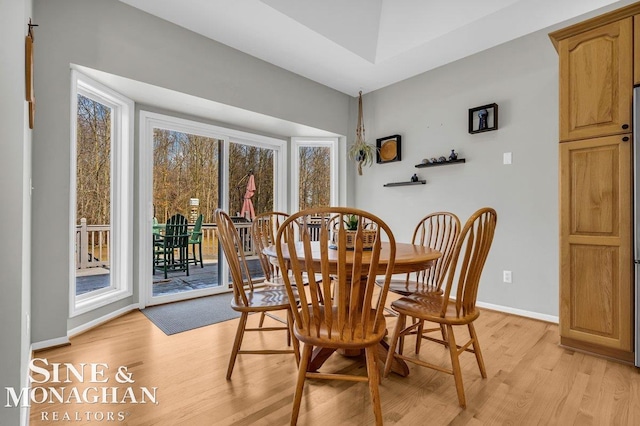 dining space with baseboards and light wood-type flooring