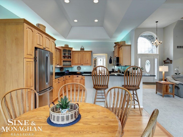 dining space featuring visible vents, light carpet, a tray ceiling, recessed lighting, and an inviting chandelier