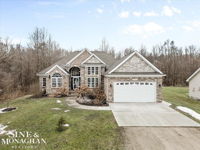 traditional-style home with a front yard, an attached garage, stone siding, and driveway