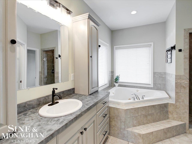 bathroom with tile patterned floors, vanity, a garden tub, and a shower stall