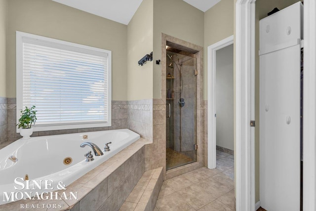 bathroom featuring tile patterned floors, a tub with jets, and a shower stall