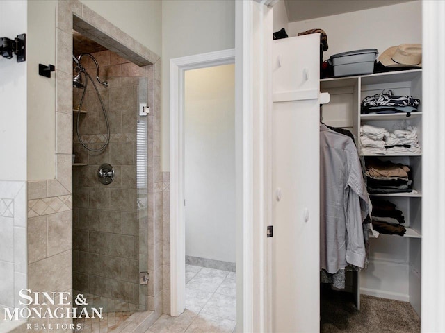 bathroom featuring a walk in closet and a stall shower