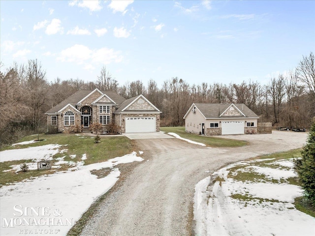 view of front of house with stone siding, a garage, and dirt driveway