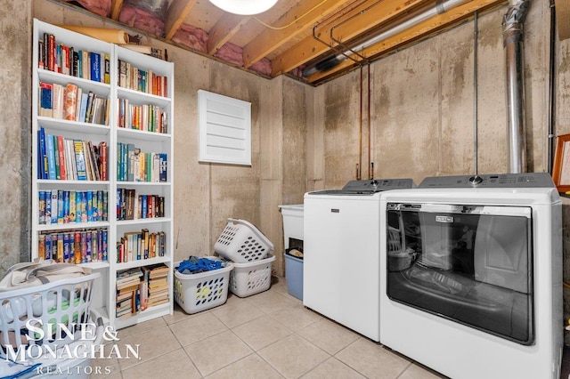 clothes washing area with light tile patterned floors and washing machine and dryer