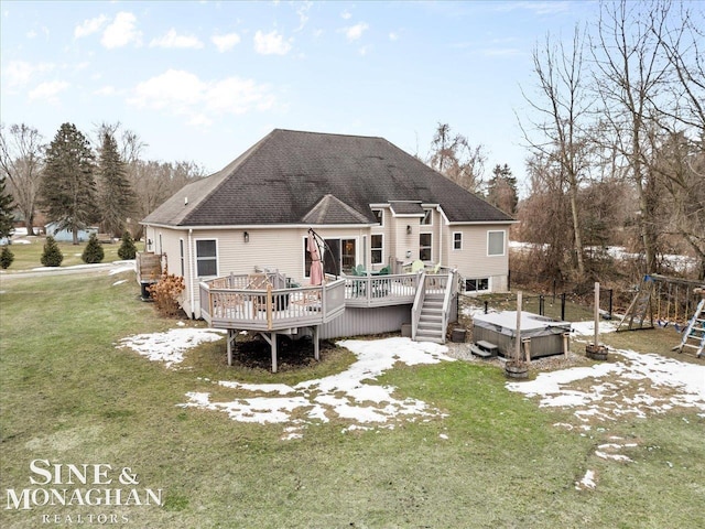 rear view of property featuring a deck, a hot tub, a yard, and roof with shingles