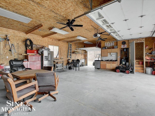 garage featuring ceiling fan, a workshop area, a garage door opener, and stainless steel fridge with ice dispenser