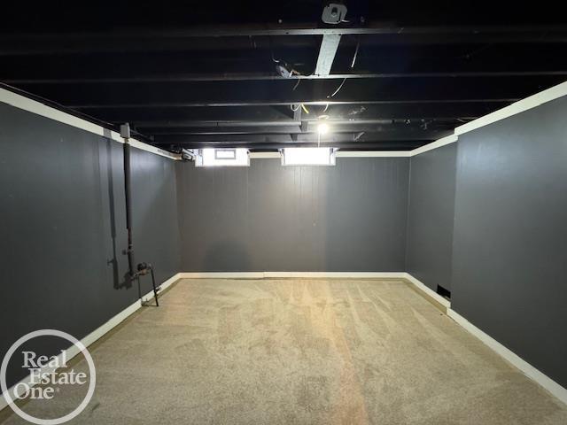 basement featuring baseboards and carpet