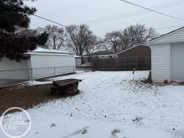 snowy yard featuring fence