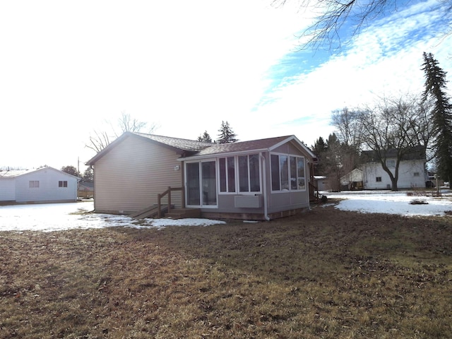 snow covered property featuring a sunroom