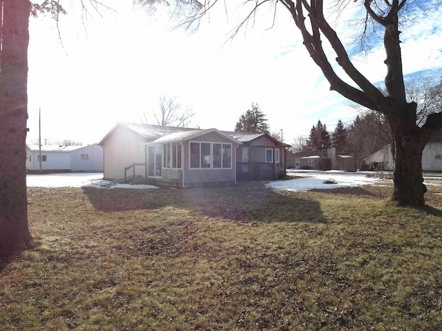 view of front of home with a front yard and a sunroom