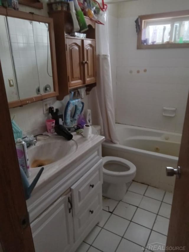 bathroom featuring shower / tub combo with curtain, toilet, vanity, and tile patterned flooring