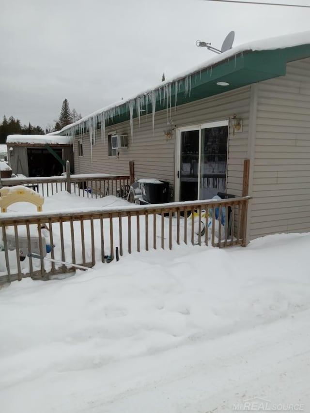 snow covered rear of property featuring a deck