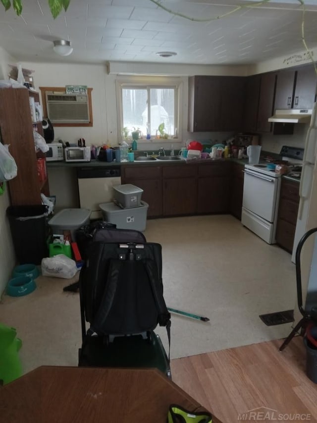 kitchen featuring under cabinet range hood, dishwashing machine, electric range, a wall mounted AC, and a sink