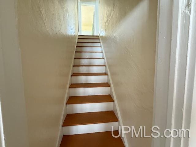 staircase with a textured wall