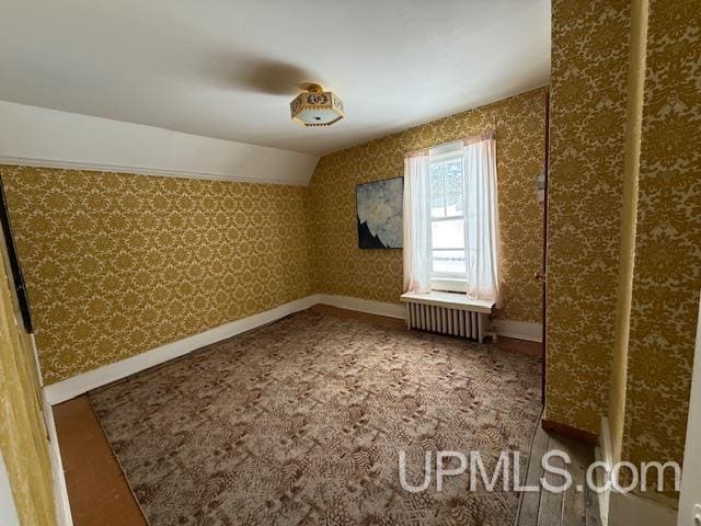 bonus room featuring wallpapered walls, vaulted ceiling, radiator heating unit, and baseboards