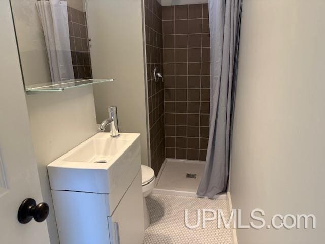 full bath with tile patterned floors, a shower stall, toilet, and vanity