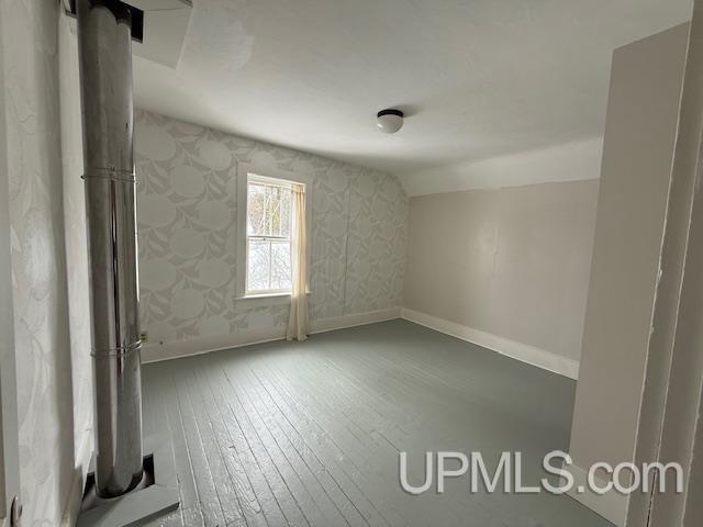 empty room featuring baseboards and hardwood / wood-style floors