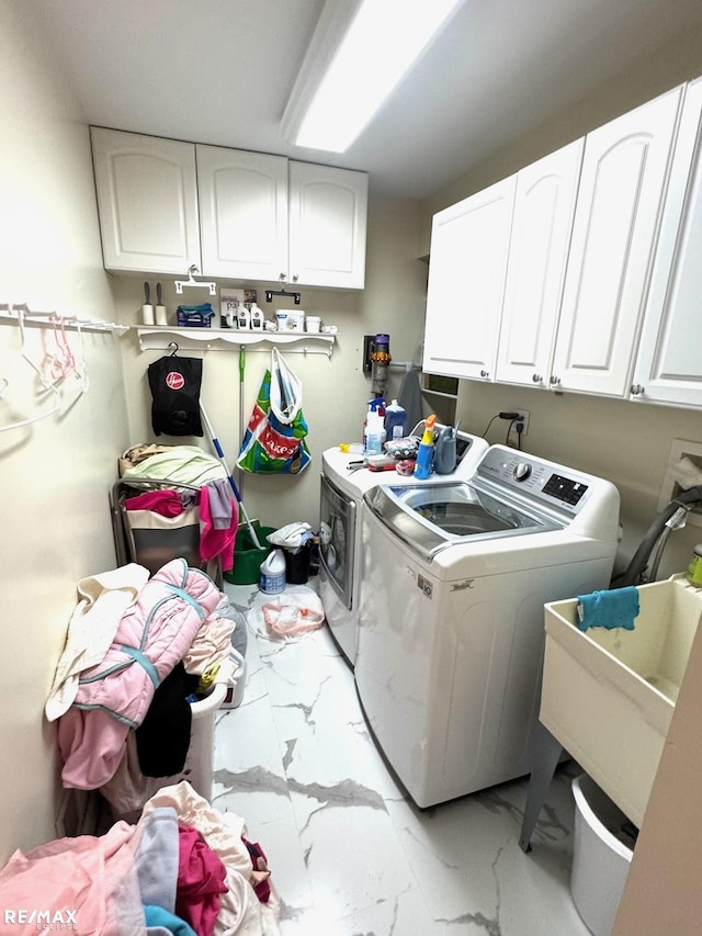 washroom featuring cabinet space, independent washer and dryer, marble finish floor, and a sink