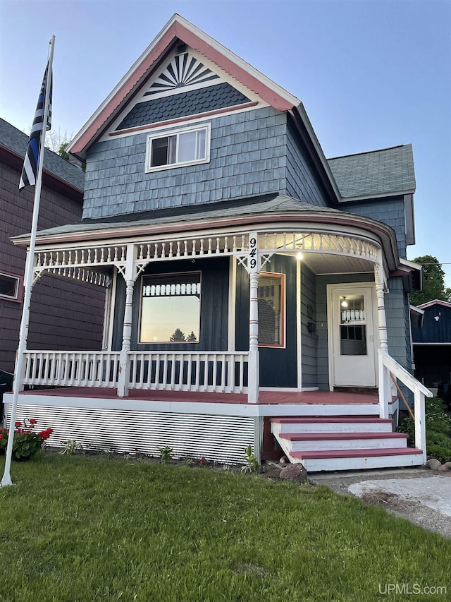 victorian house with a front lawn and covered porch