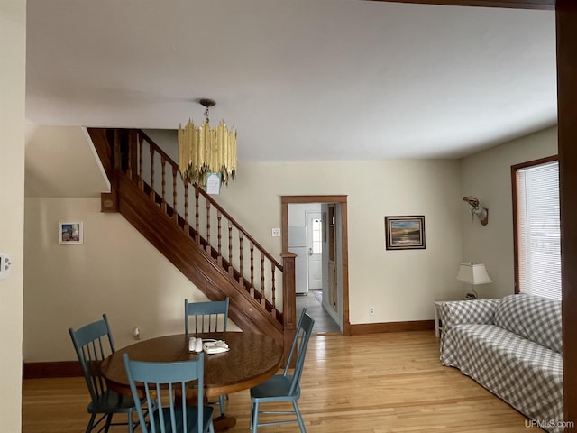 living room featuring stairway, light wood-style flooring, and baseboards