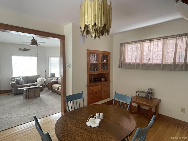 dining area featuring wood finished floors, baseboards, and ceiling fan