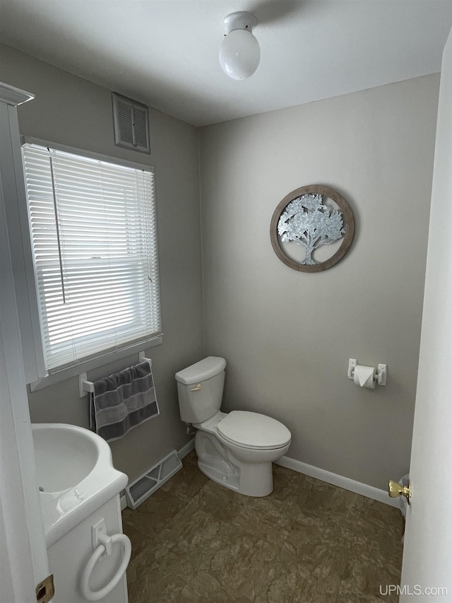 bathroom with visible vents, toilet, vanity, and baseboards