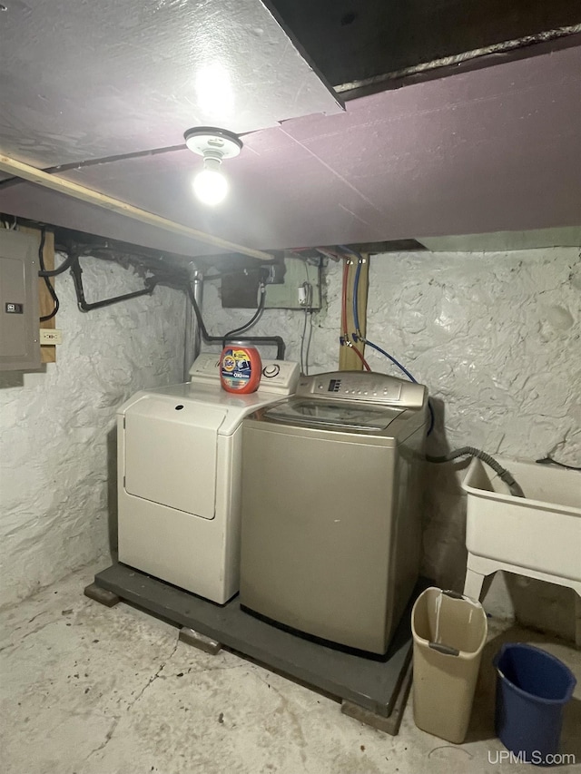 clothes washing area with washer and dryer, laundry area, and electric panel