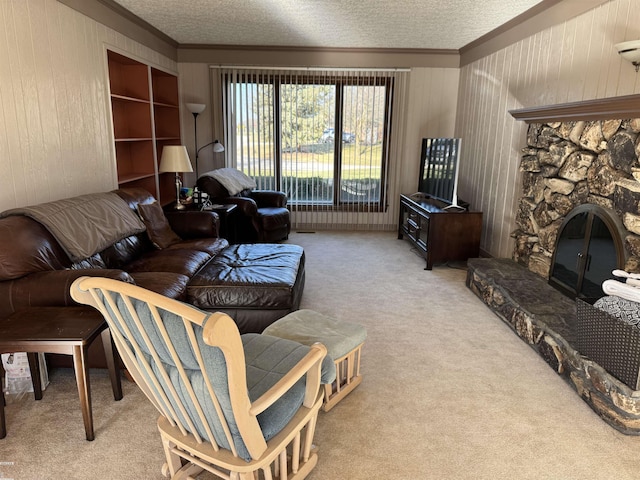 carpeted living room with wood walls, a fireplace, a textured ceiling, and ornamental molding