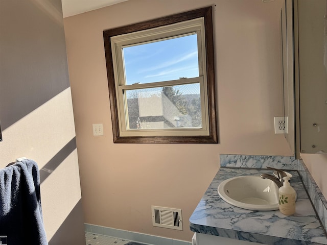 bathroom featuring vanity, baseboards, and visible vents