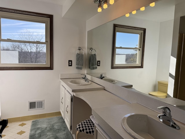 full bath featuring double vanity, visible vents, and a sink