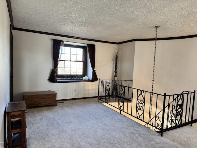 empty room featuring carpet flooring, a textured ceiling, and ornamental molding