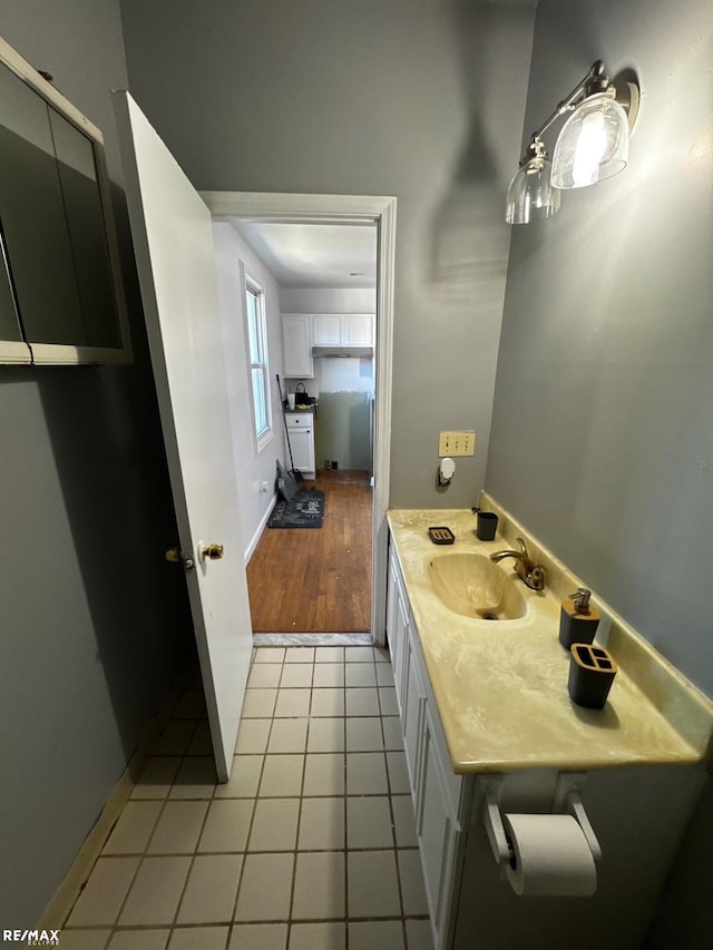 bathroom with tile patterned floors, baseboards, and a sink