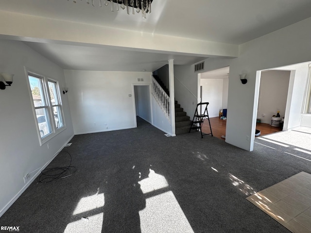 unfurnished living room with visible vents, baseboards, carpet flooring, and stairs