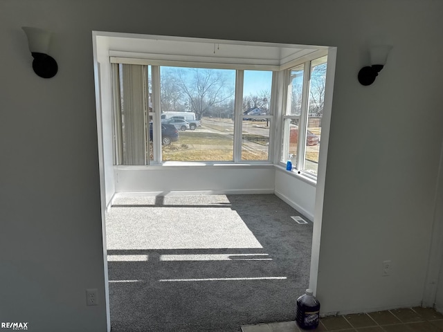 spare room with visible vents, baseboards, and carpet floors