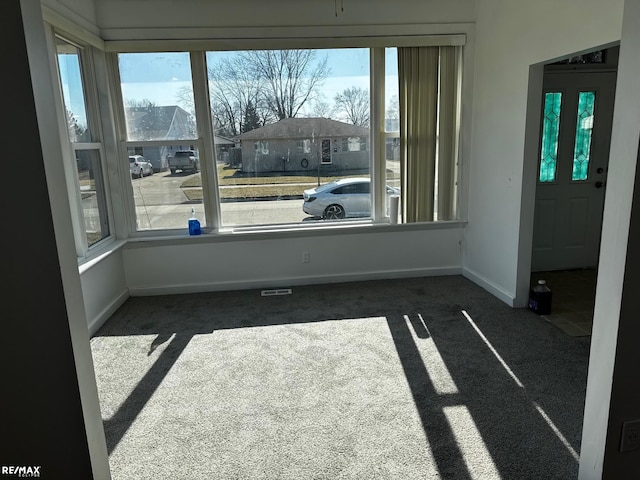 empty room with a residential view, baseboards, and dark colored carpet