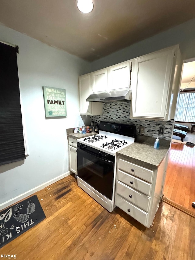 kitchen featuring range with gas stovetop, decorative backsplash, and white cabinetry